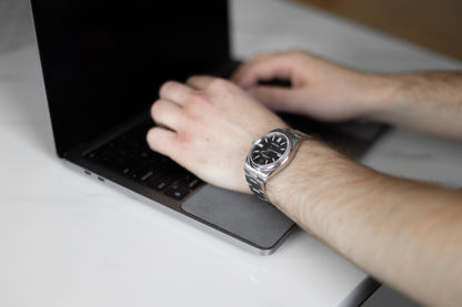 Close up of man working on his computer while wearing a nice watch using the WatchPad, preventing scratches on his luxury watch.